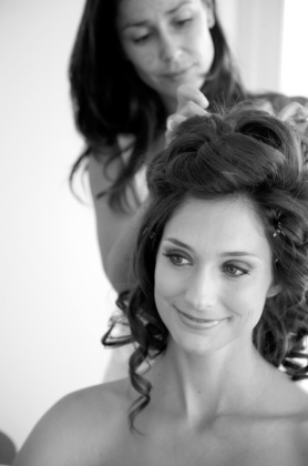 Professional makeup and hair artist styling a bride during a preparation session in Ibiza
